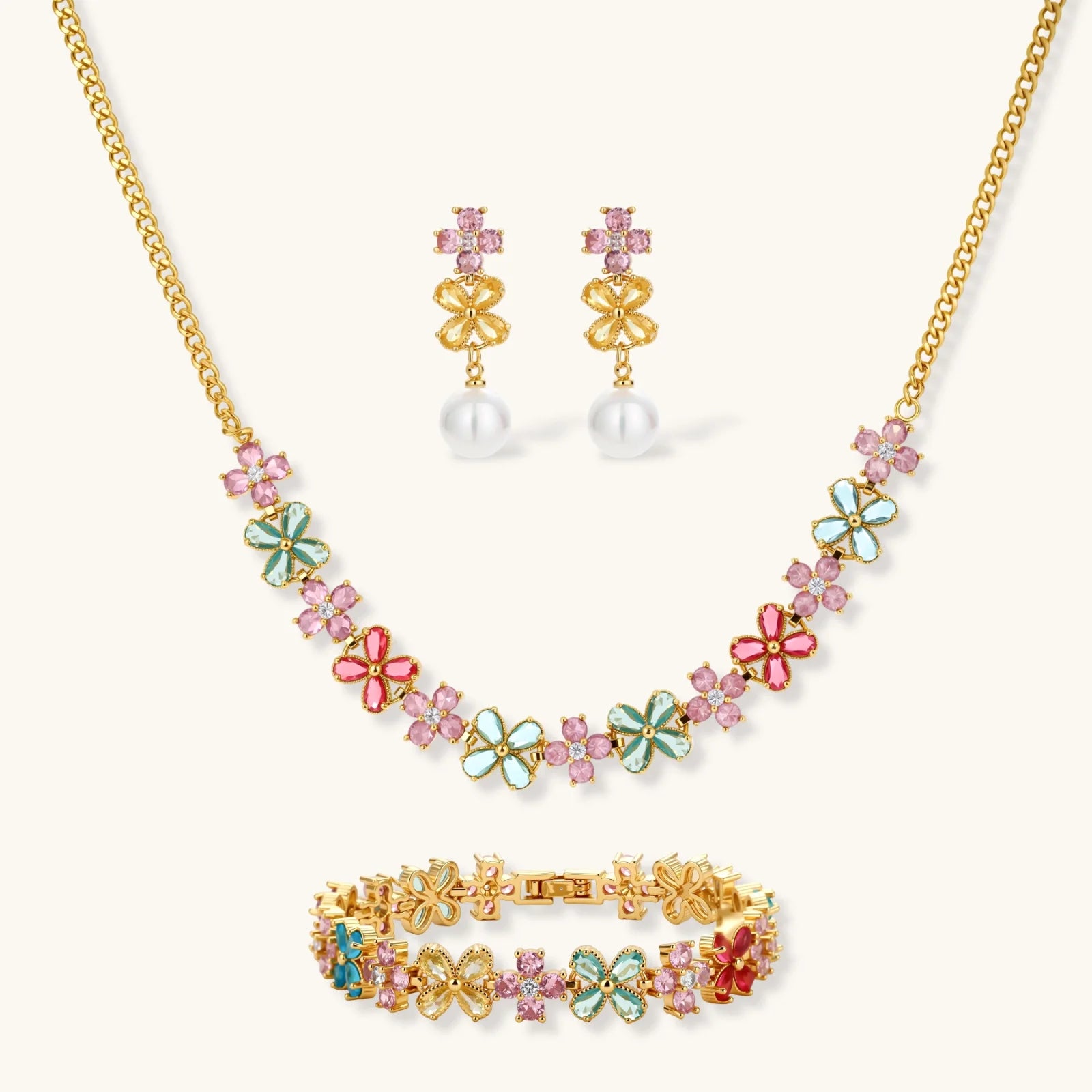 Gold-plated jewelry set with pink, turquoise and red flower-shaped cubic zirconia stones, featuring necklace, earrings and bracelet.