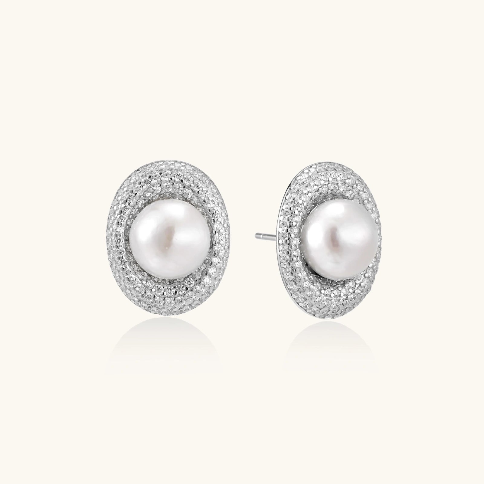 Elegant stud earrings with cream freshwater pearls surrounded by sparkly pavé crystals on rhodium-plated silver setting